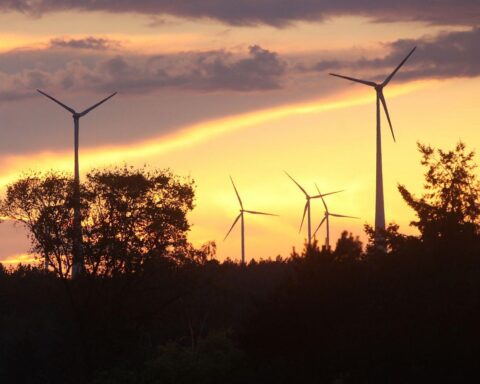 Windräder vor bewölktem Himmel, Symbol für den Wandel des Wetters in Baden-Württemberg.