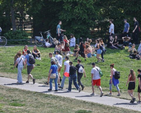 Junge Menschen genießen sommerliches Wetter unter klarem Himmel, heiter und ohne Regen.
