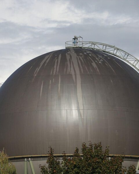Gasspeicher im Hintergrund, symbolisierende Charts und das Bundeswirtschaftsministerium in der Diskussion über Energiestrategie.