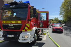 Feuerwehr rettet Mutter und Baby nach Wohnungsbrand in Mehrfamilienhaus, Rauchentwicklung aus Küche.