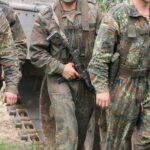 Soldaten der Bundeswehr und Zettel für Kriegsdienstverweigerung in entspanntem Umfeld.