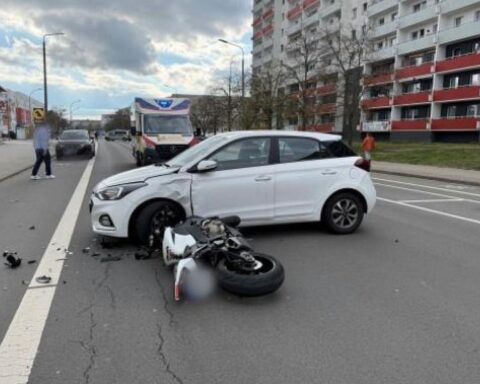 Unfallstelle mit Motorrad und Auto, Rettungsdienst vor Ort, Schadensbilder und Polizei.