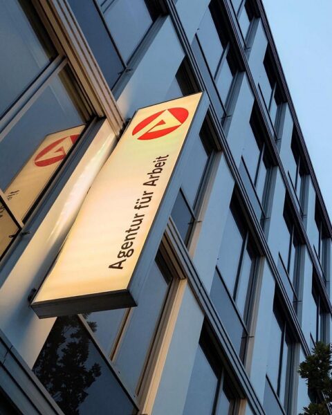 Ein Bild von zufriedenen Arbeitnehmern, die Prämienempfang feiern, symbolisiert Unterstützung und finanzielle Entlastung.