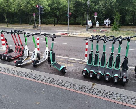 E-Scooter auf der Straße, umgeben von Bremsspuren und Absperrband, Unfallstelle in Wolfsburg.