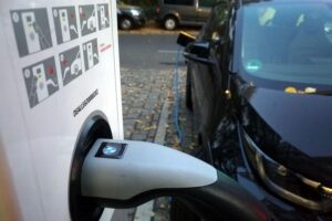 Elektroauto tankt an Ladestation – Herausforderungen der Ladeinfrastruktur in Deutschland sichtbar.