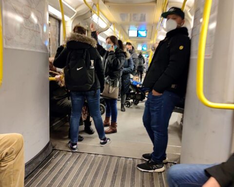 Menschen in einer U-Bahn während der Corona-Pandemie, symbolisch für gesellschaftliche Einschränkungen.