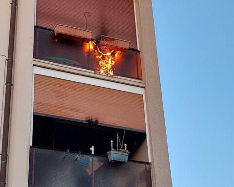 Balkon eines Mehrfamilienhauses, Feuerwehr im Einsatz, Löschmaßnahmen gegen Balkonbrand.