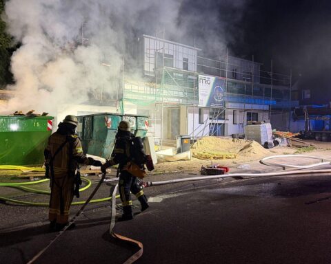 Baucontainerbrand mit Feuerwehr im Einsatz, Flammen und Rauch, nachts in Remscheid.