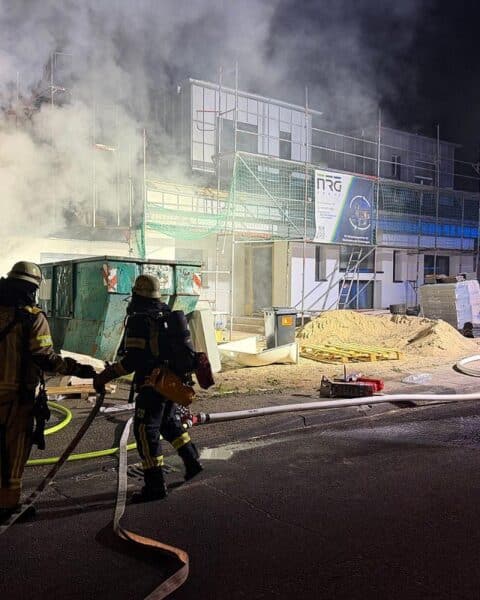 Baucontainerbrand mit Feuerwehr im Einsatz, Flammen und Rauch, nachts in Remscheid.