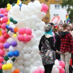Bunte Parade mit Menschen, die Vielfalt und Solidarität für LSBTIQ feiern, im Stadtbild.