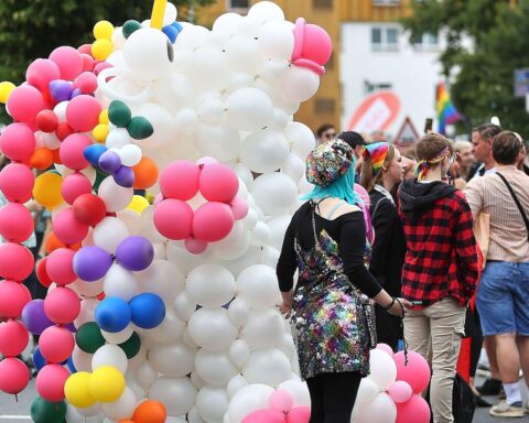 Bunte Parade mit Menschen, die Vielfalt und Solidarität für LSBTIQ feiern, im Stadtbild.