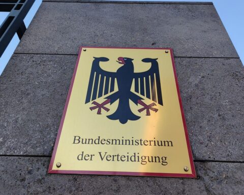 Bundesregierung einigt sich auf Panzerhersteller-Beteiligung: Amtsgebäude, Politiker und Panzer im Hintergrund.