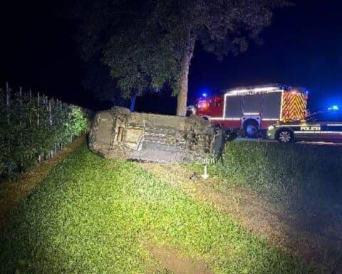 Ein schwerer Auto-Unfall: Umgestürztes Fahrzeug, Straßenkreuzung, Polizei und Feuerwehr im Einsatz.