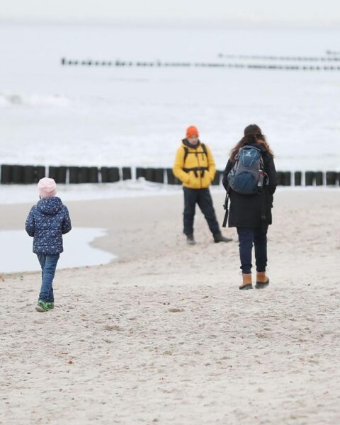 Familien am Strand, symbolisierend Stabilität und Zusammenhalt trotz geplanter Elterngeld-Reformen.