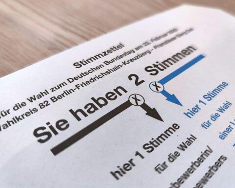 Stimmzettel zur Bundestagswahl 2025 mit Informationen zum Wahlalter und Merz' Ablehnung einer Herabsetzung.