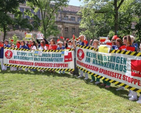 Krankenhausproteste gegen Kürzungspläne, Beschäftigte zeigen rote Karten und fordern bessere Gesundheitsversorgung.