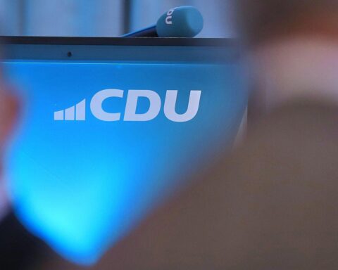 CDU-Logo vor Hintergrund der Luftfahrtforschung, Symbol für Dringlichkeit und politischen Druck.