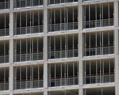 Hochhaus-Baustelle mit Bauarbeitern, Baumaschinen und Gerüsten für Wohnungsbau in Deutschland.
