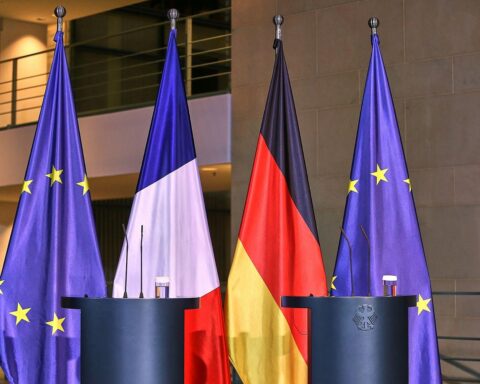 Drei Fahnen: Deutschland, Frankreich und EU, symbolisieren enge Zusammenarbeit in nuklearer Sicherheit.