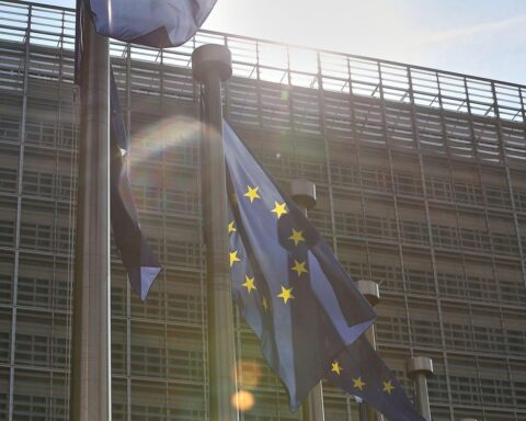 EU-Fahnen symbolisieren neue Regeln für Künstliche Intelligenz und Regulierung von Hochrisiko-Systemen.