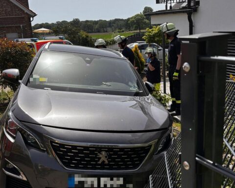 Einsatzkräfte der Feuerwehr bei einem Verkehrsunfall, Ölspur und Rettungseinsatz in Schermbeck.