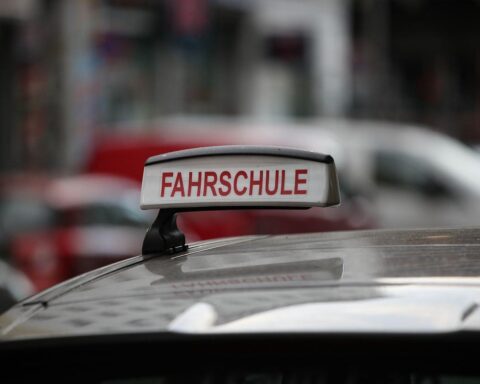 Fahrschule mit Laienausbildung: Schüler und Fahrlehrer auf Straße, Verkehrssicherheit im Fokus.