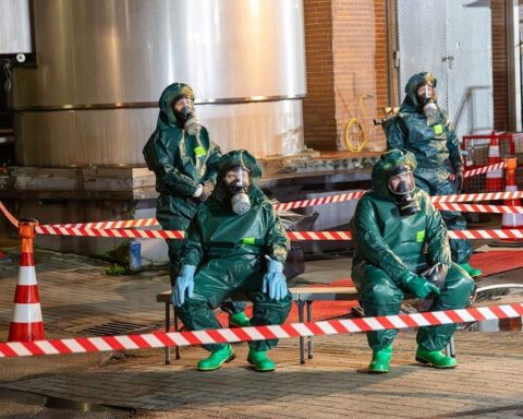 Feuerwehr im Einsatz bei Gefahrgutaustritt in Milchbetrieb; Chemikalienschutz und Rauchmeldung sichtbar.