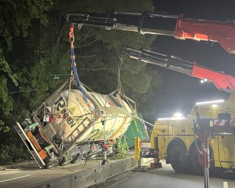 Szenen eines Gefahrgutunfalls: Feuerwehrleute arbeiten an einem verunfallten Lastwagen auf der Straße.