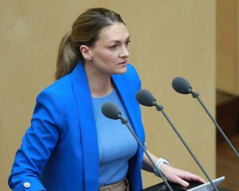 Frau im Freien untersucht sich auf Zecken, vor Pfingstferien, Zeckenwarnung, Gesundheitsrisiken.