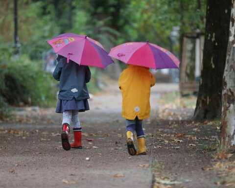 Zwei Kleinkinder spielen im Herbst, während Gewitterwarnungen für Baden-Württemberg aktuell sind.