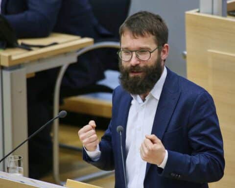 Sebastian Striegel vor einem Hintergrund, der digitale Kommunikation und Demokratie symbolisiert.