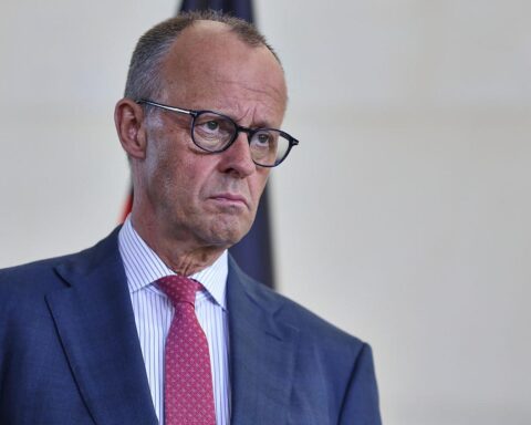 Friedrich Merz in Berlin, umgeben von politischen Symbolen, Ausdruck von Besorgnis und Führungsschwäche.