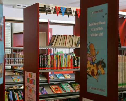 Kinder entdecken Geschichten, symbolisch Übergang von Kita zur Grundschule, unterstützt von Büchern und Audio.