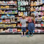 Kinder wählen fröhlich Süßigkeiten im Supermarkt, symbolisieren Haribos wachsenden Absatz und Markenbeliebtheit.