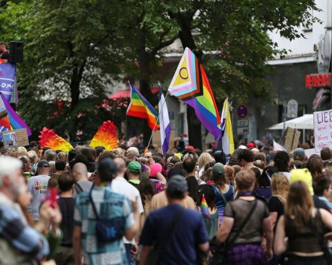 Bunte Parade mit Stolzflaggen, Menschen feiern Vielfalt, Franzosen demonstrieren gegen Hass und Diskriminierung.