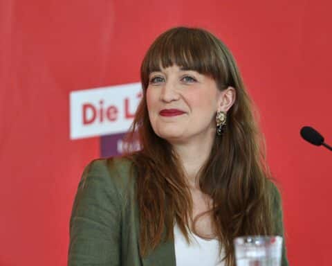 Heidi Reichinnek spricht auf der Bühne, umringt von interessierten Bürgern in Sachsen.