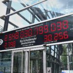 Eine Uhr zeigt steigende Staatsverschuldung, symbolisiert wirtschaftliche Probleme und notwendige Sparmaßnahmen.