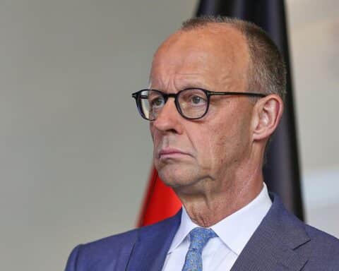 Friedrich Merz zeigt besorgte Miene; Unzufriedenheitsstatistik der Deutschen im Hintergrund.