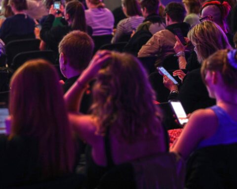Junge Menschen nutzen Smartphones, während Sorgen über Social-Media-Abhängigkeit und Regulierung aufkommen.