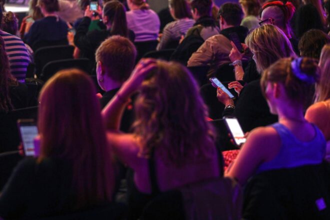 Junge Menschen nutzen Smartphones, während Sorgen über Social-Media-Abhängigkeit und Regulierung aufkommen.