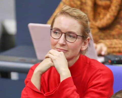 Ines Schwerdtner präsentiert sich optimistisch vor dem Parteitag, umringt von Parteikollegen und Herausforderungen.