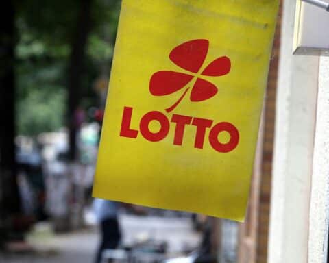 Ein Lotto-Schild mit Zahlen, Jackpot-Hinweis und Warnung vor Spielsucht.