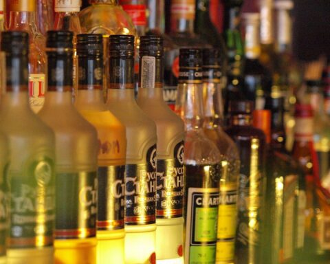 Wodka-Flaschen in einem Verkaufssortiment, symbolisieren den Aufruf zu strengeren Alkoholregelungen.