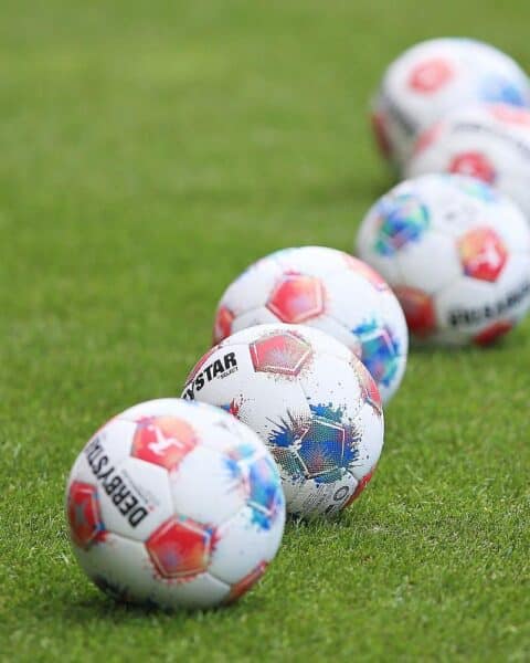 Ein Fußballtorwart mit VfB Stuttgart-Trikot, der den Ball hält, symbolisiert Rückkehr und Erfahrung.