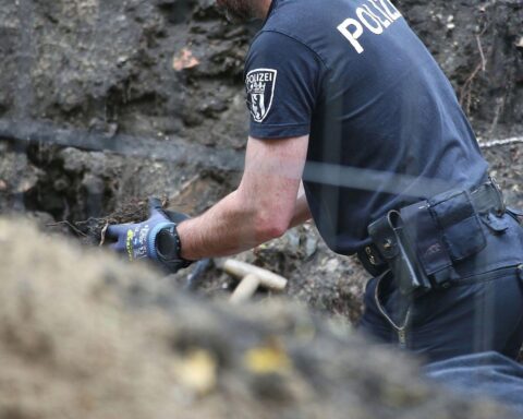 Polizisten untersuchen menschliche Knochenreste auf einem Spielplatz in Berlin-Kreuzberg.