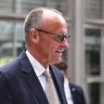 Friedrich Merz im Vordergrund, im Hintergrund Koalitionsgespräche zwischen Union und SPD skizziert.