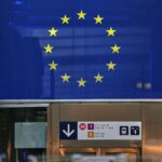 EU-Fahne vor dem Hintergrund wirtschaftlicher Bedenken zu Firmenfusionen und Wettbewerbsfähigkeit.