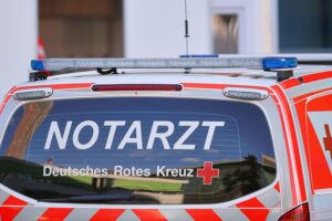 Vermisster 81-Jähriger tot in Münsing aufgefunden Ein Notarztteam bei einem Einsatz am Badesee, gekennzeichnet durch Tragik und Ernsthaftigkeit.