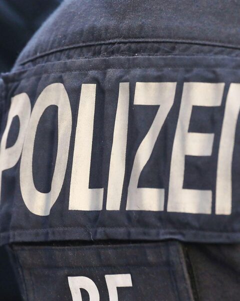 Eine verletzte Frau auf einem Kiesweg, umgeben von Rettungskräften und Polizei.