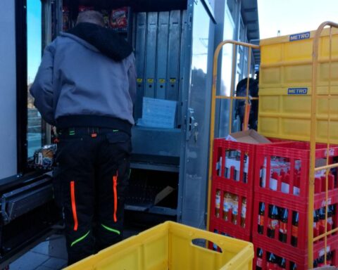 Ein Getränkeautomat wird aufgefüllt mit verschiedenen Erfrischungsgetränken in einer Fabrik.